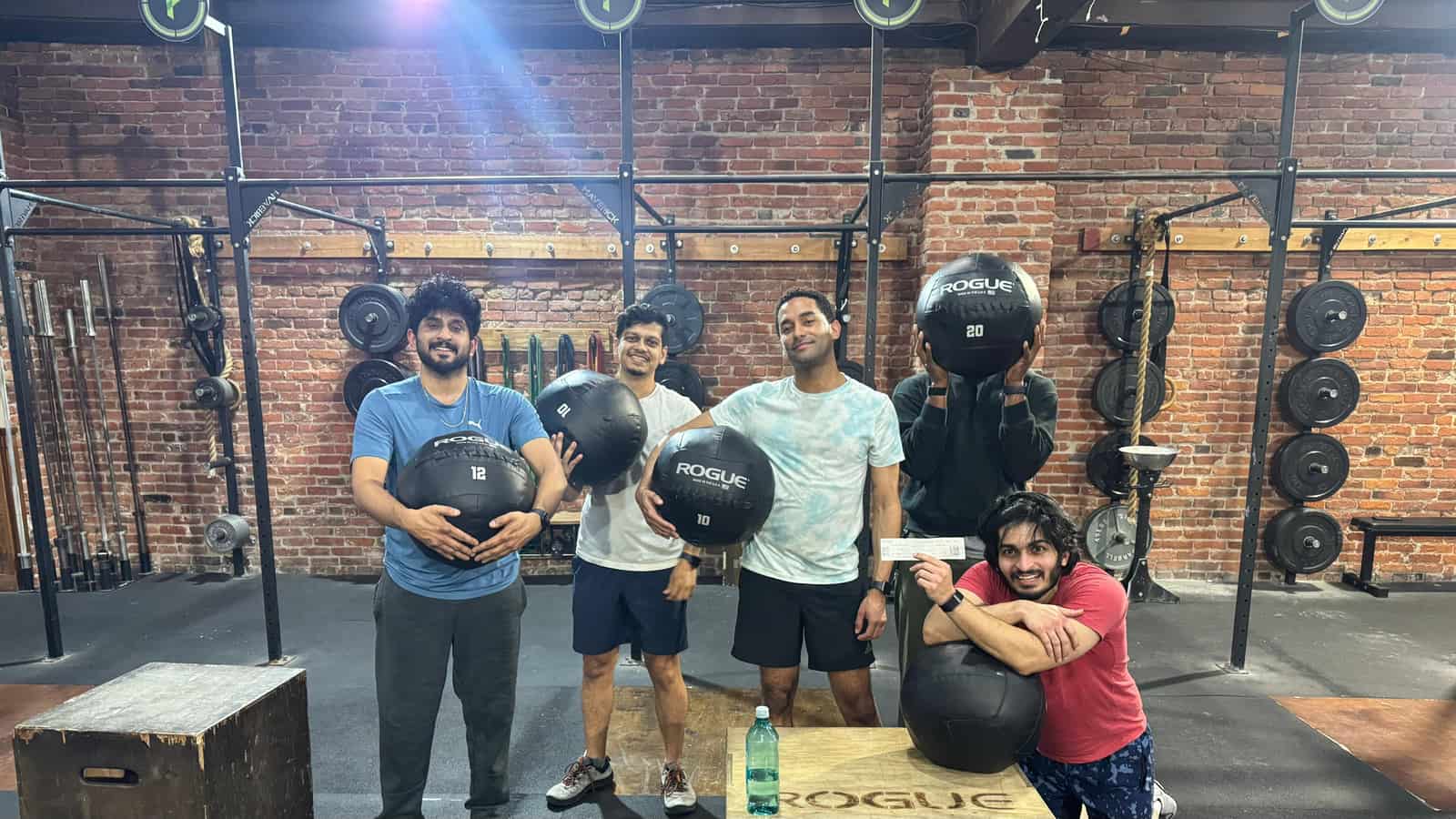 Four Persistence Athletics members holding wall balls together, Belltown Seattle