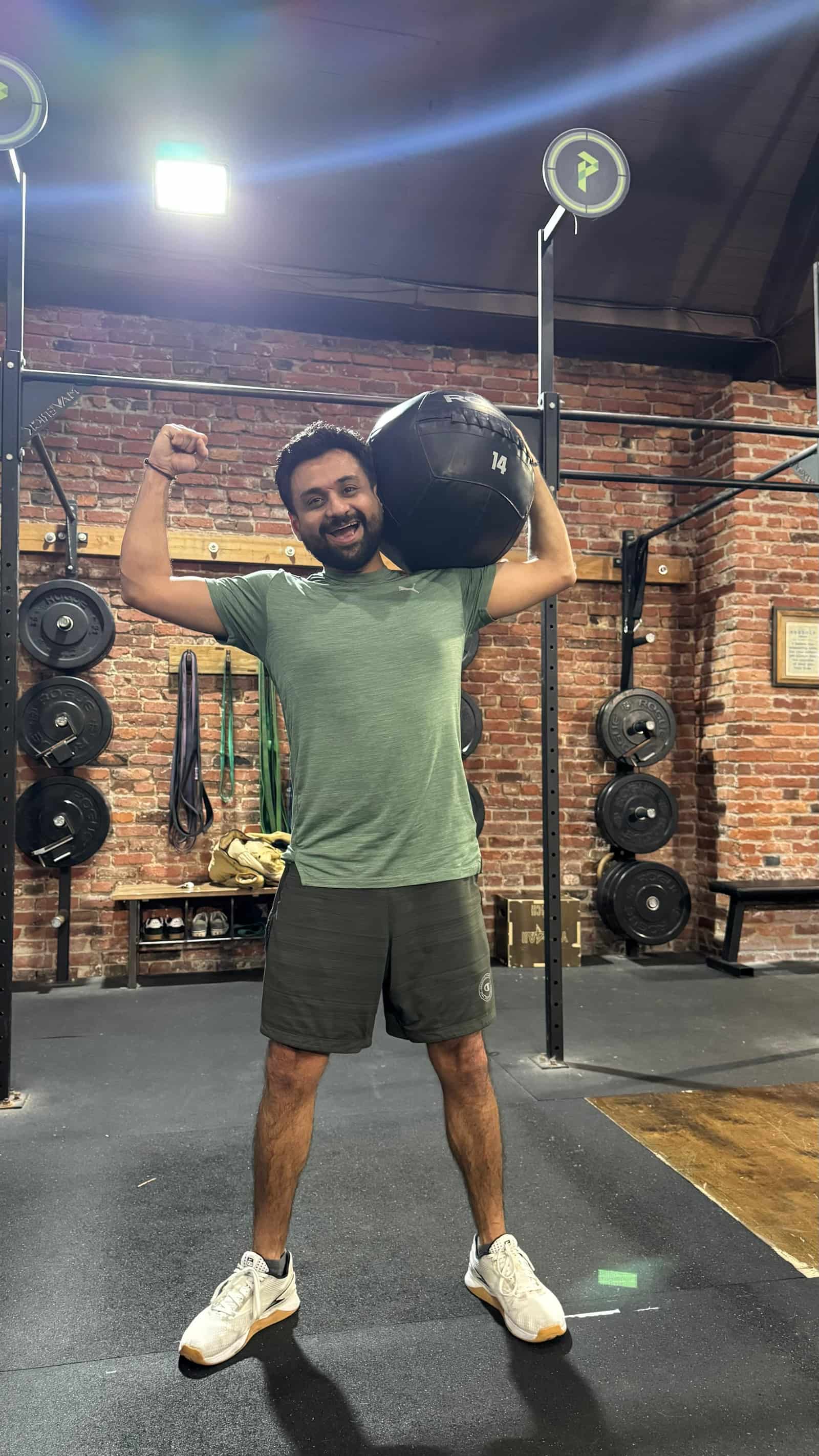 Persistence Athletics member flexing with a wall ball after a workout, Belltown Seattle