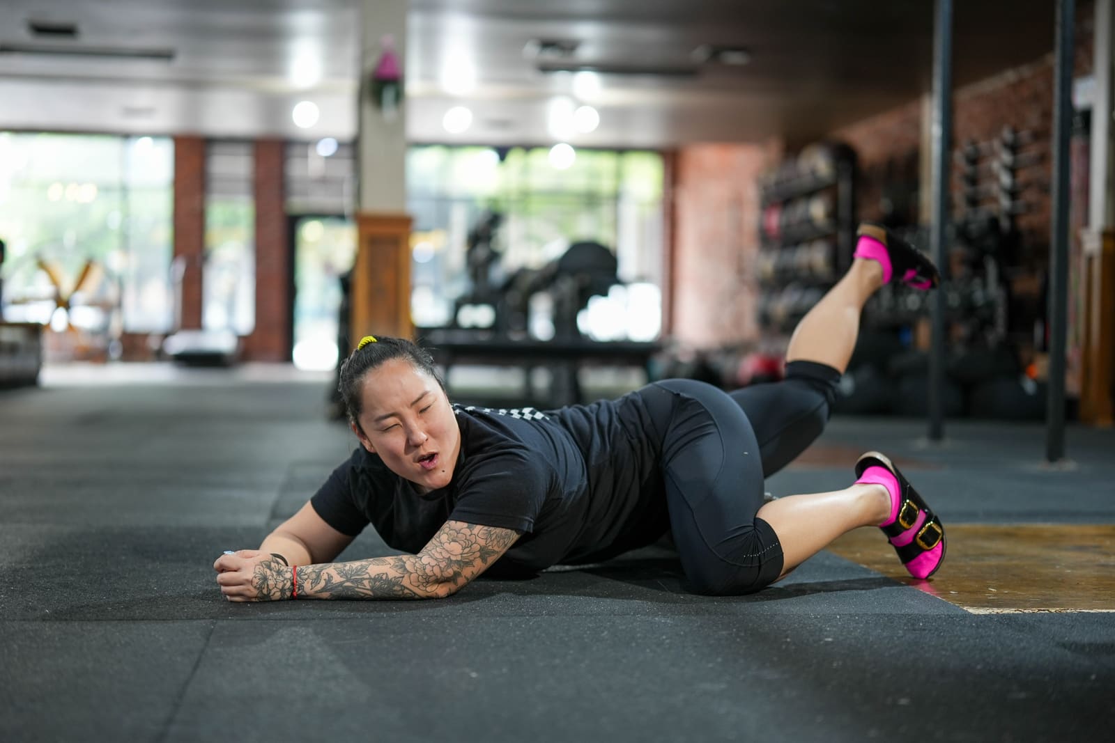 Member on the floor doing hip mobility at Persistence Athletics, Belltown Seattle
