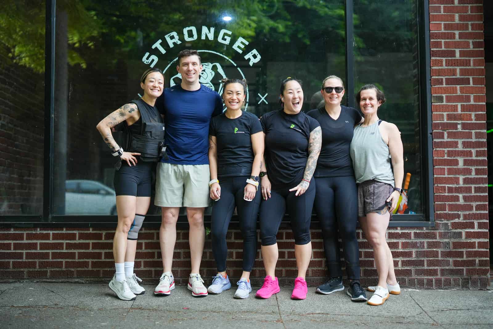 Six Persistence Athletics members posing in front of the STRONGER sign, Belltown Seattle