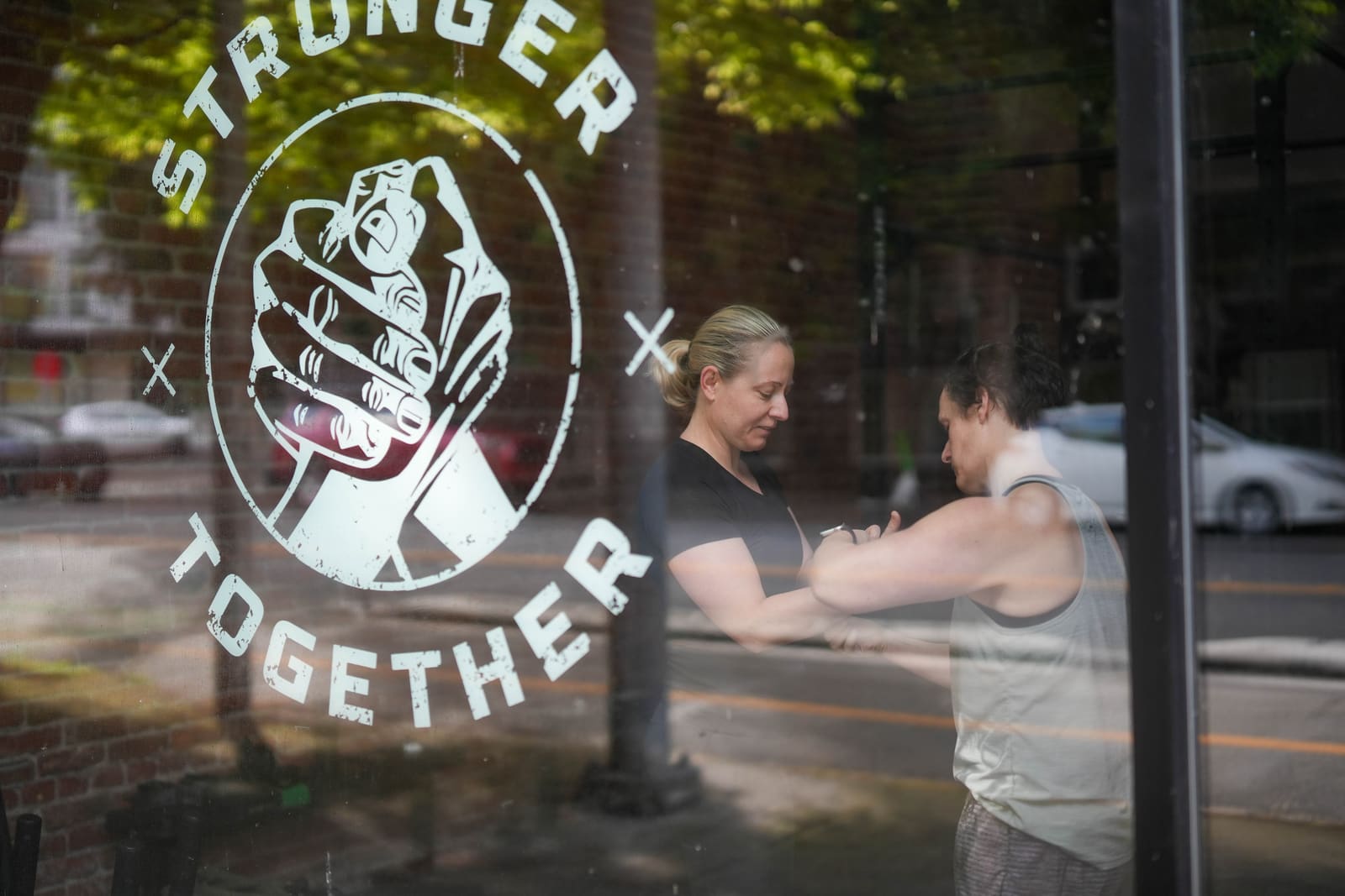 Persistence Athletics STRONGER TOGETHER window with members behind, Belltown Seattle