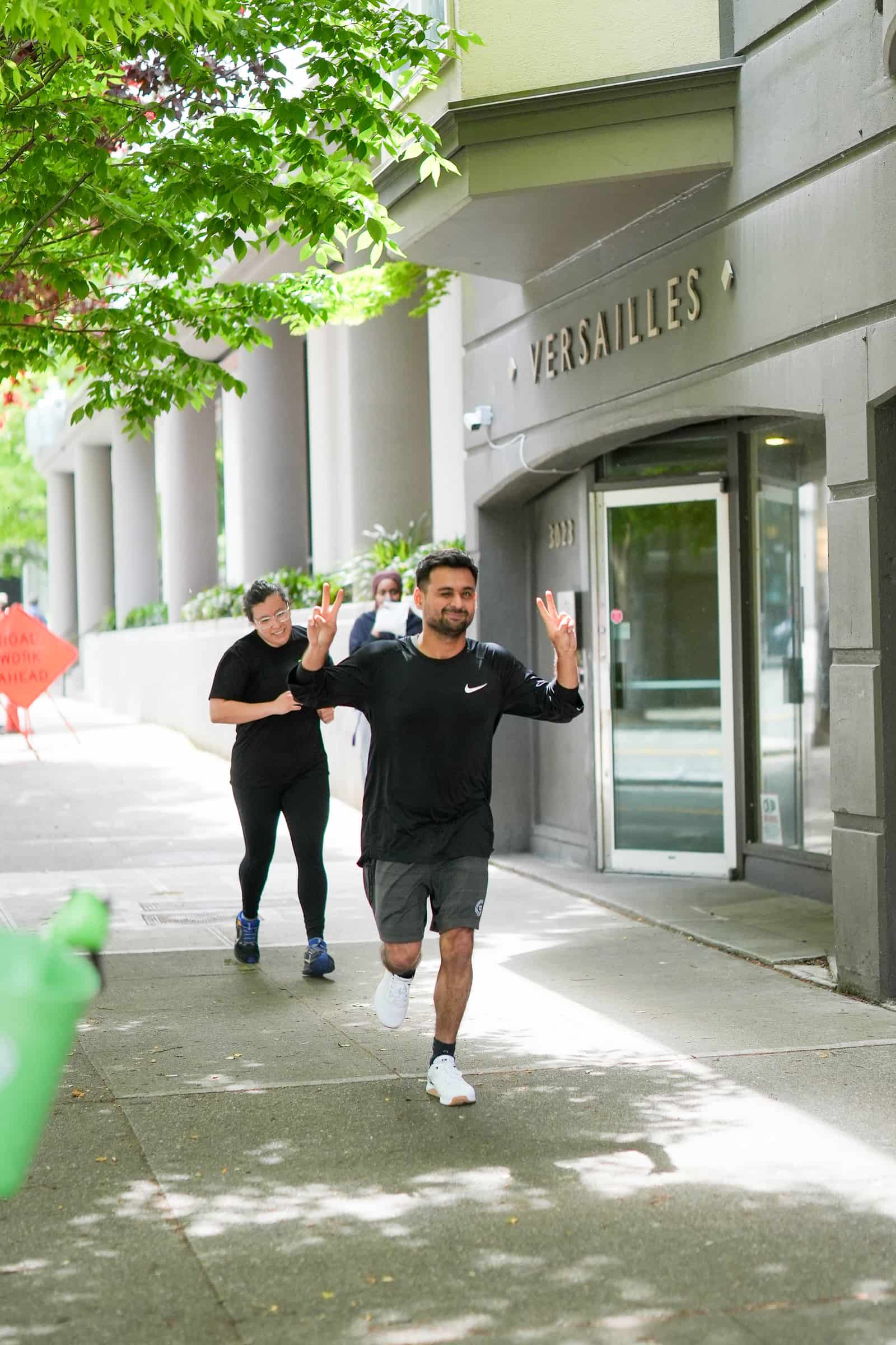 Two Persistence Athletics members running on the Belltown sidewalk, Seattle