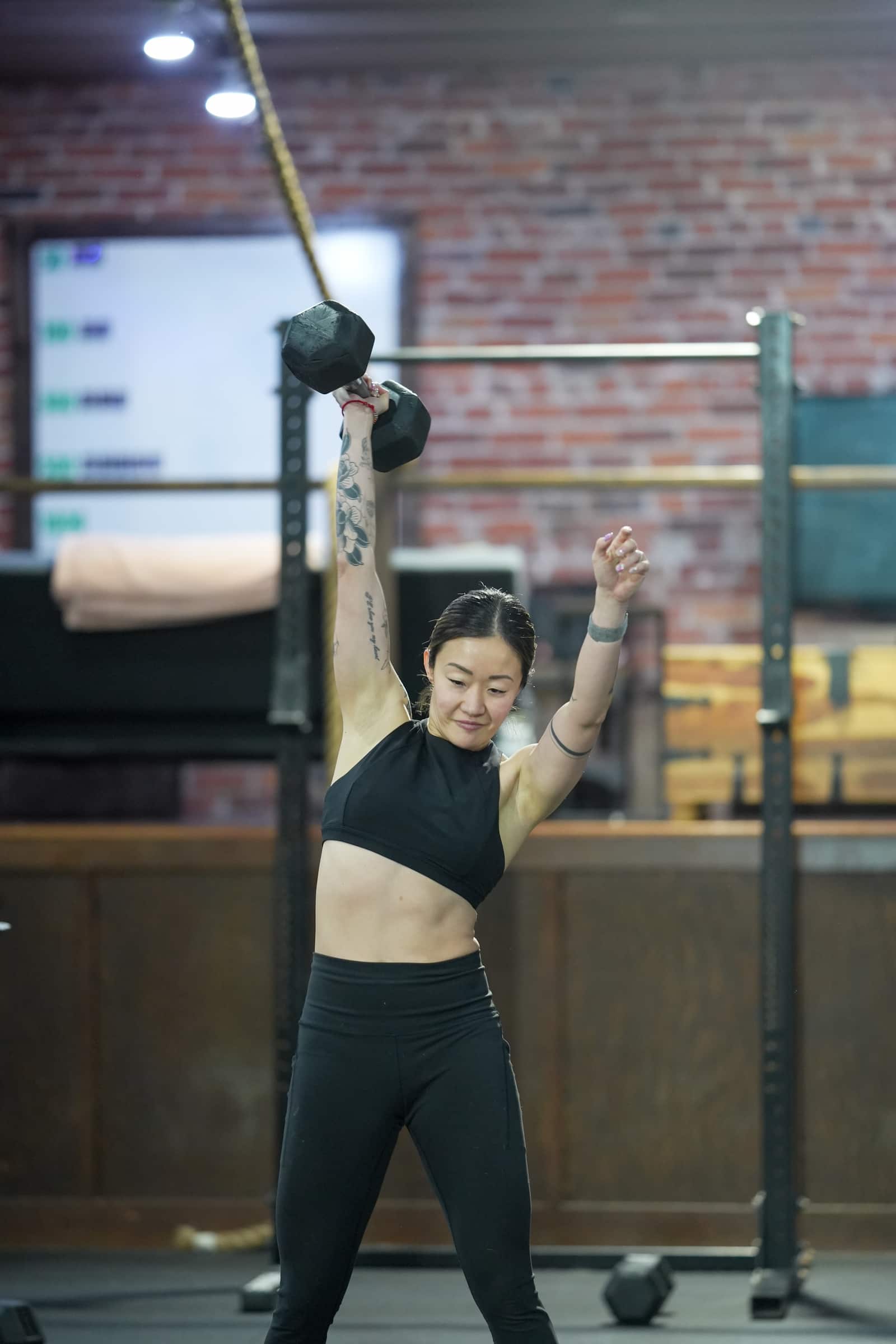 Member celebrating a snatch lockout during the CrossFit Open at Persistence Athletics, Belltown Seattle
