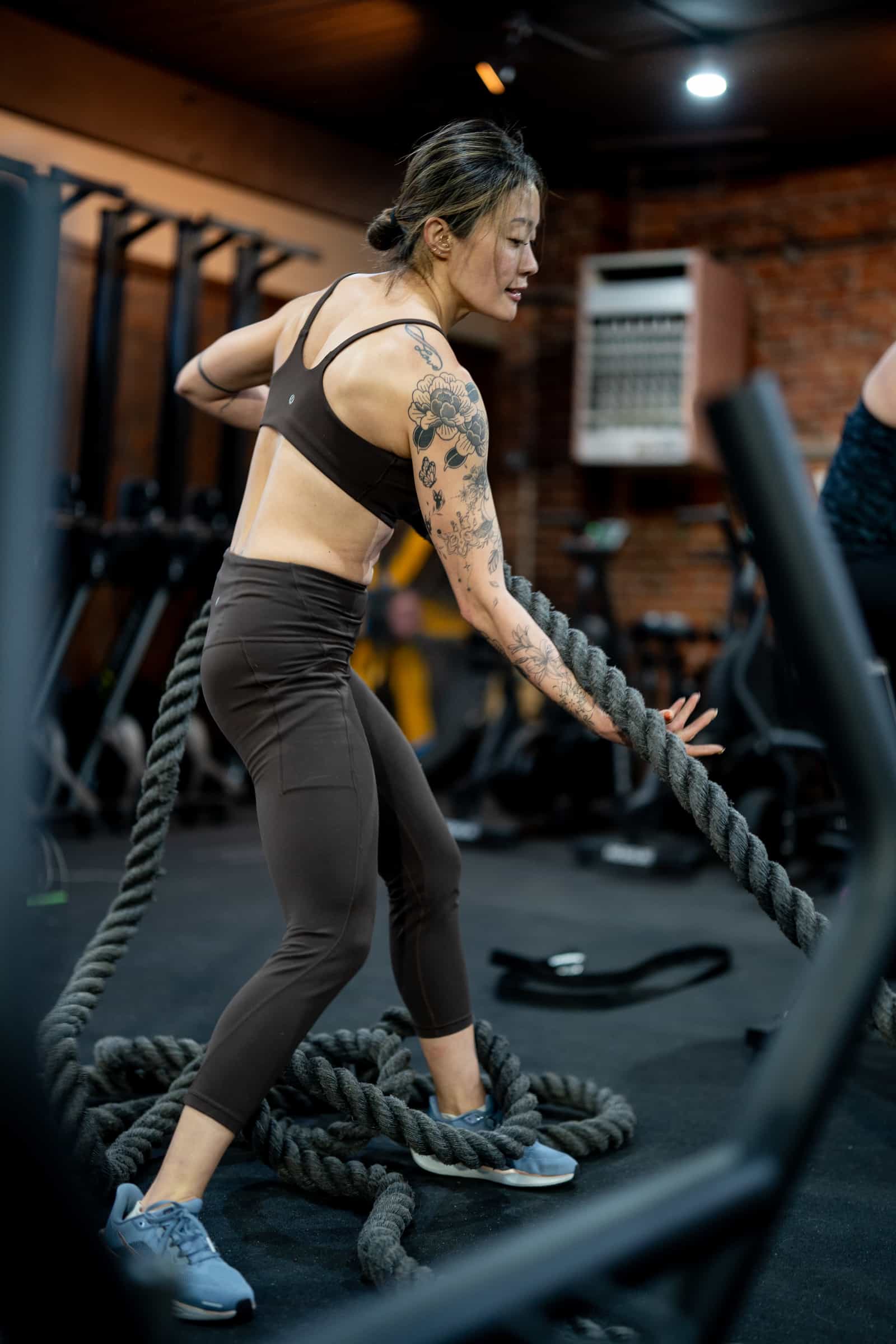 Member focused on battle ropes during a metcon at Persistence Athletics, Belltown Seattle
