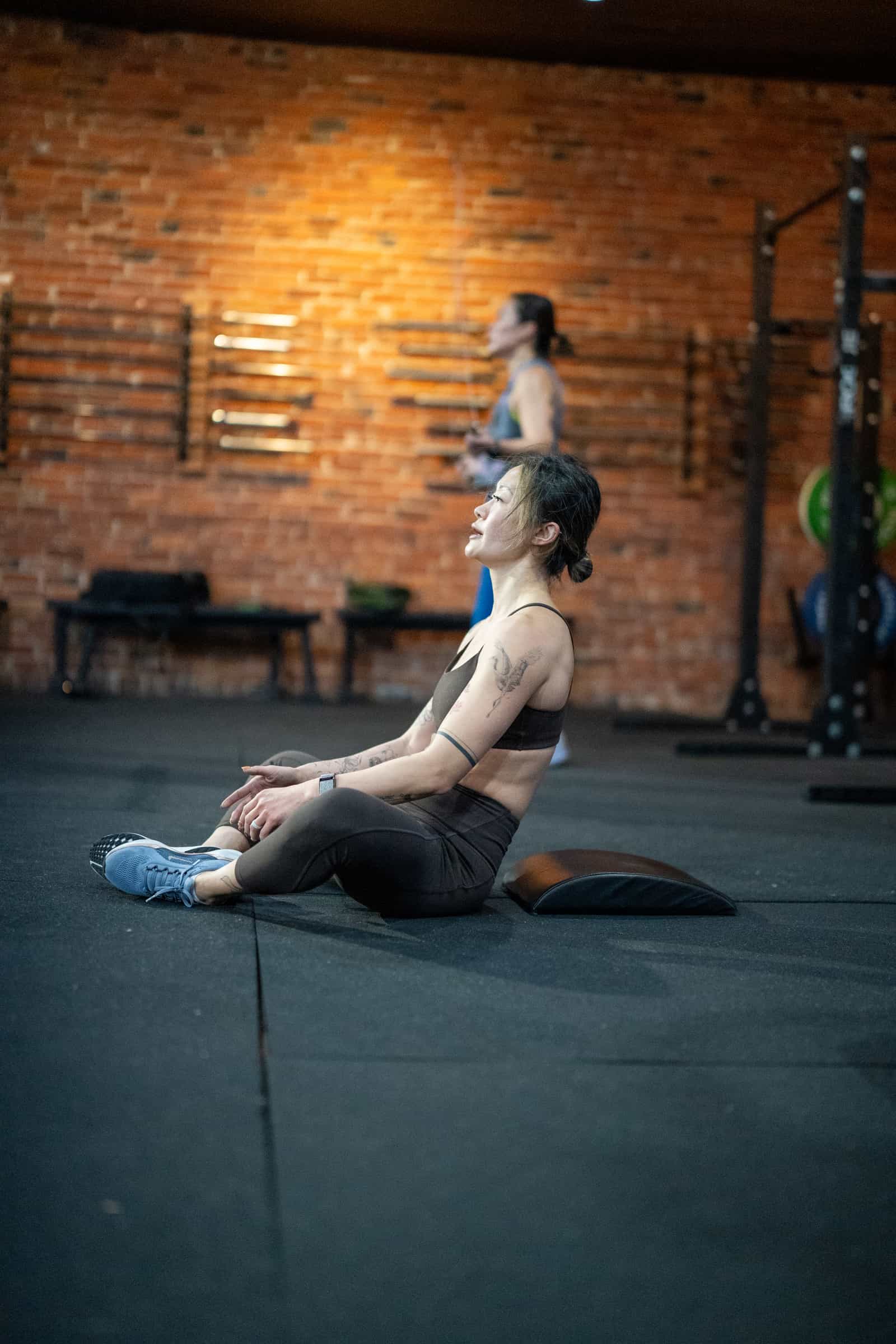 Member doing seated forward fold mobility at Persistence Athletics, Belltown Seattle